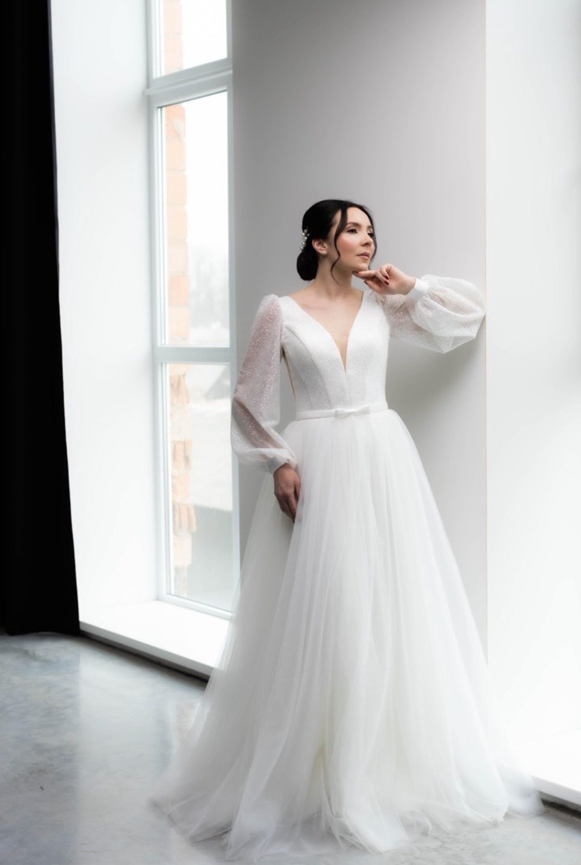 Svatební šaty — model u okna